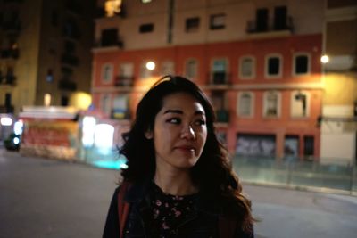 Portrait of beautiful woman in city at night