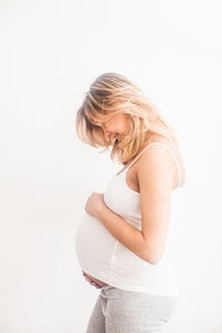 Side view of woman standing against white background