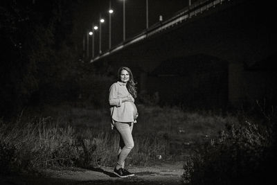 Woman standing on field at night