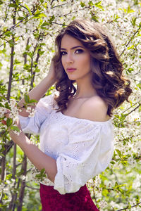 Portrait of a young girl brown hair with make-up in the cherry sakura pink ,white in a red skirt