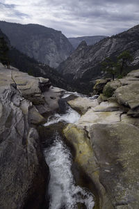 Scenic view of river amidst mountains against sky