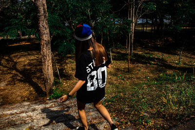 Rear view of woman walking in forest