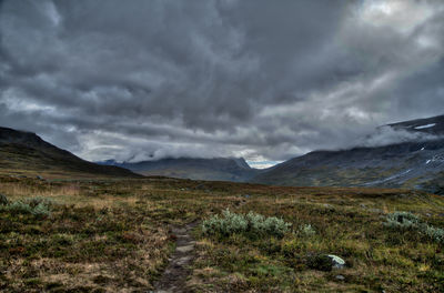 Scenic view of mountains against cloudy sky