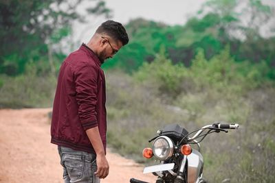 Young man looking at his bike.