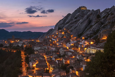 Aerial view of illuminated cityscape against sky during sunset