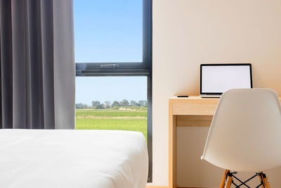 Empty chairs and table by window at home