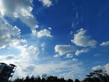 Low angle view of silhouette trees against blue sky