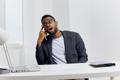 Portrait of young man working at desk in office