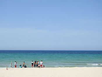 People on beach against sky