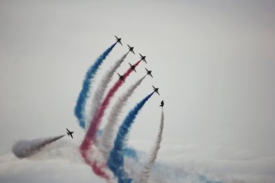 Low angle view of airshow against sky