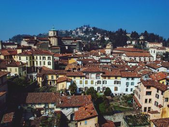 High angle view of houses in town against clear blue sky