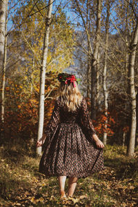 Rear view of woman walking in forest