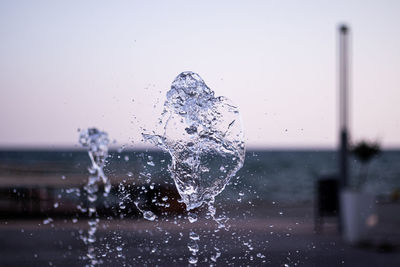 Close-up of water splashing against clear sky