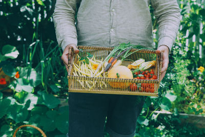 Midsection of man holding basket