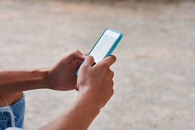 Close-up of a young man writing a massage in his phone