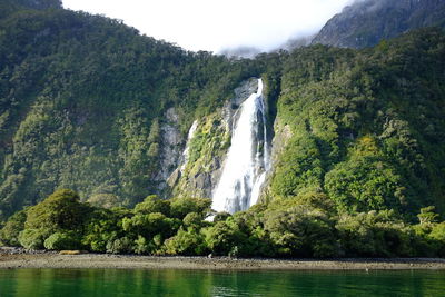 Scenic view of waterfall against sky