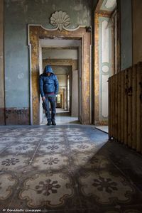 Rear view of man walking in corridor