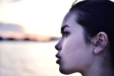 Close-up portrait of a young woman looking away