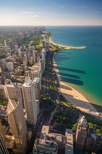 High angle view of city by sea against sky at night