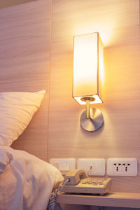 Illuminated electric lamp on bed at home