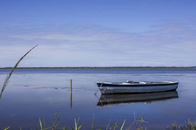 Boat moored in lake against sky