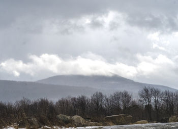 Scenic view of mountains against cloudy sky