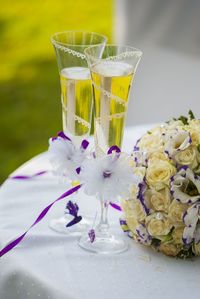 High angle view of champagne flutes by bouquet on table during wedding