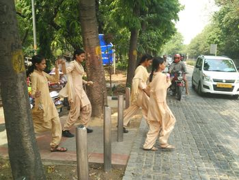 People standing by tree in city