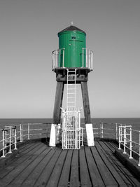 Lifeguard hut by sea against sky