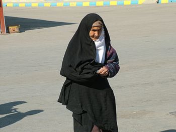 Full length of young woman standing in snow