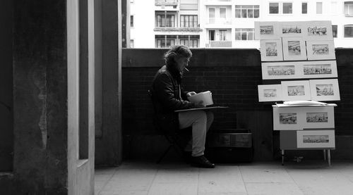 Side view of a man sitting on floor