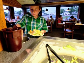 Boy eating food in restaurant
