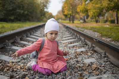 Rear view of girl on railroad track