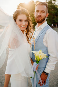 Portrait of smiling young couple standing outdoors