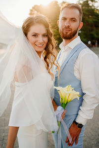 Portrait of smiling young couple standing outdoors