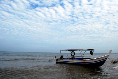 Boat moored on sea against sky