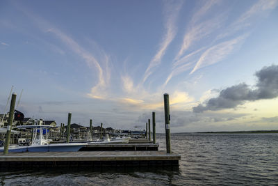 Pier over sea against sky during sunset