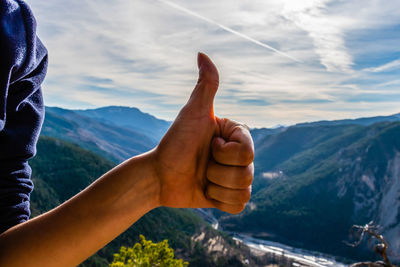 Midsection of person on mountain against sky