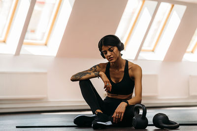 Full length of woman resting at gym