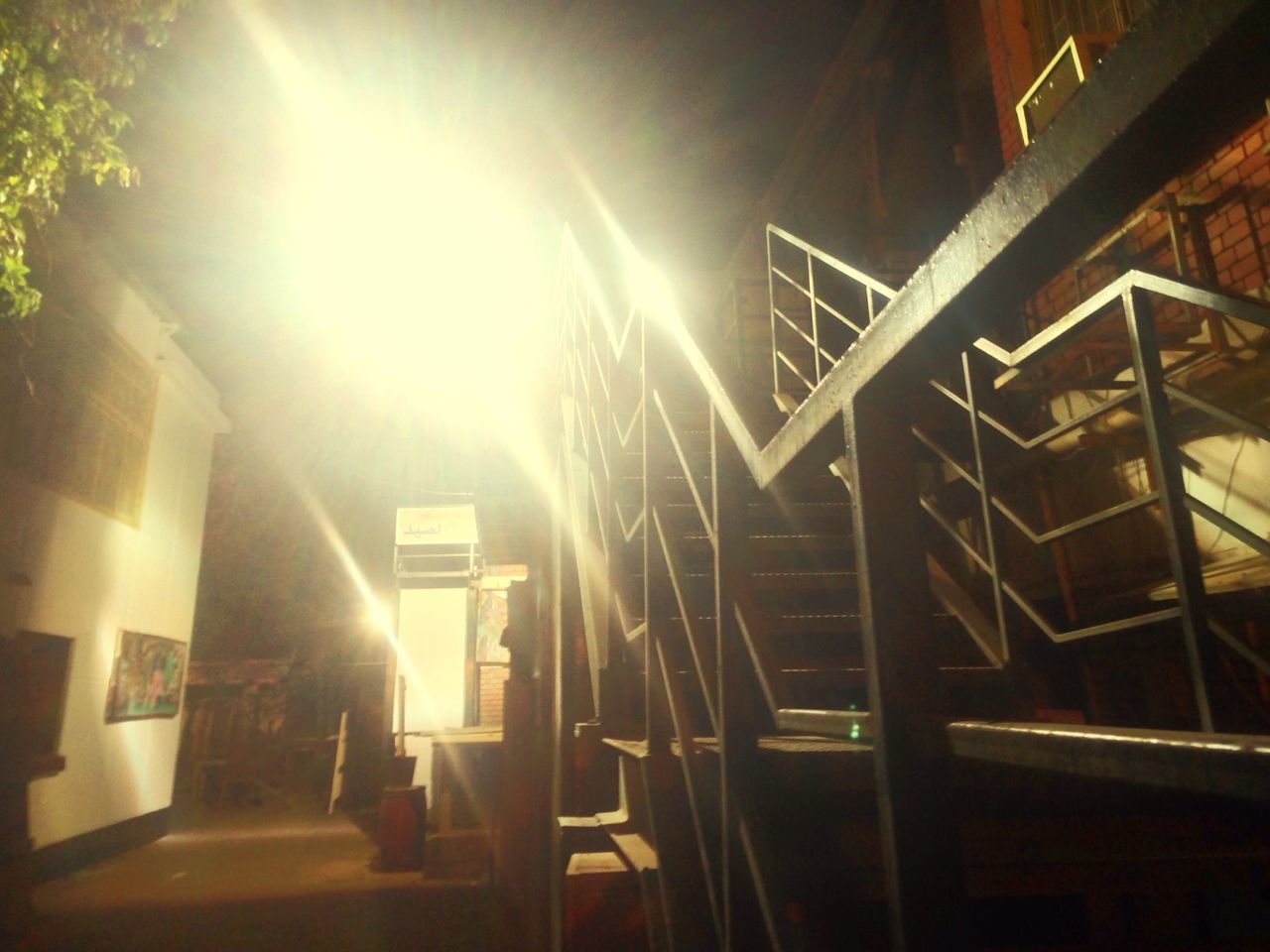 built structure, architecture, railing, illuminated, low angle view, sunlight, night, staircase, steps, building exterior, steps and staircases, indoors, sunbeam, no people, lens flare, lighting equipment, house, building, absence, light - natural phenomenon