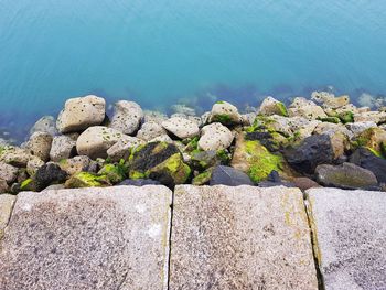 High angle view of stone wall by sea