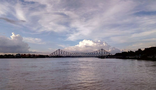 View of bridge over sea against cloudy sky
