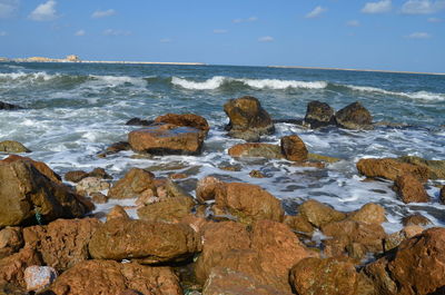 Rocks on beach against sky