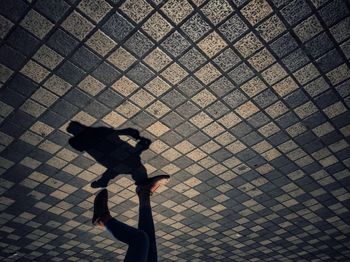 Silhouette man walking on cobblestone street