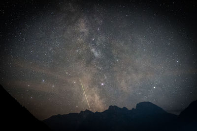 Scenic view of silhouette mountains against star field at night