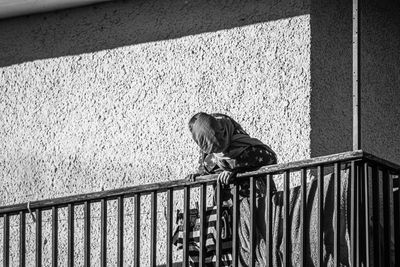 Side view of woman standing against railing