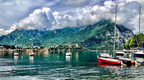 Sailboats moored on sea against sky