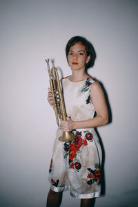 Portrait of young woman holding a trumpet 