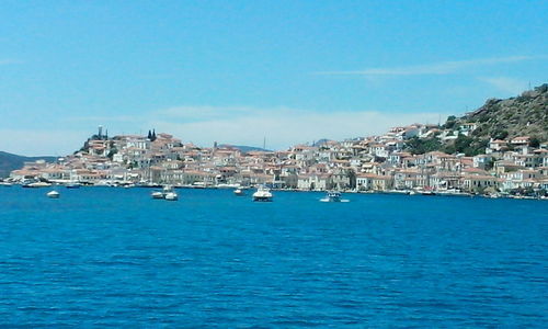 View of buildings in sea against blue sky