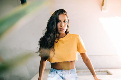 Portrait of beautiful woman standing against wall